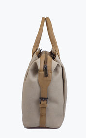 A beige canvas duffel bag with tan leather handles and trim, shown from the side against a plain white background.