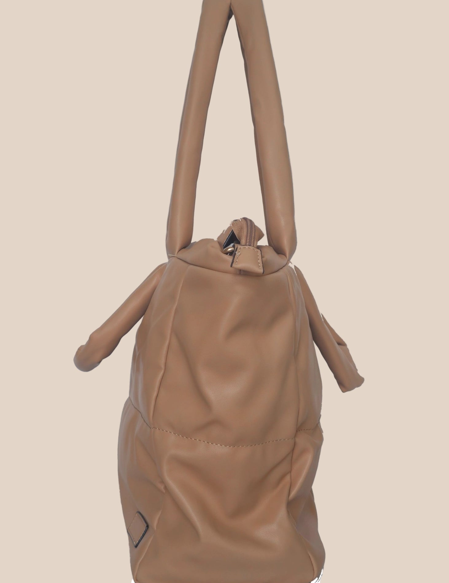 Brown smooth form handbag with a strap and handles side view