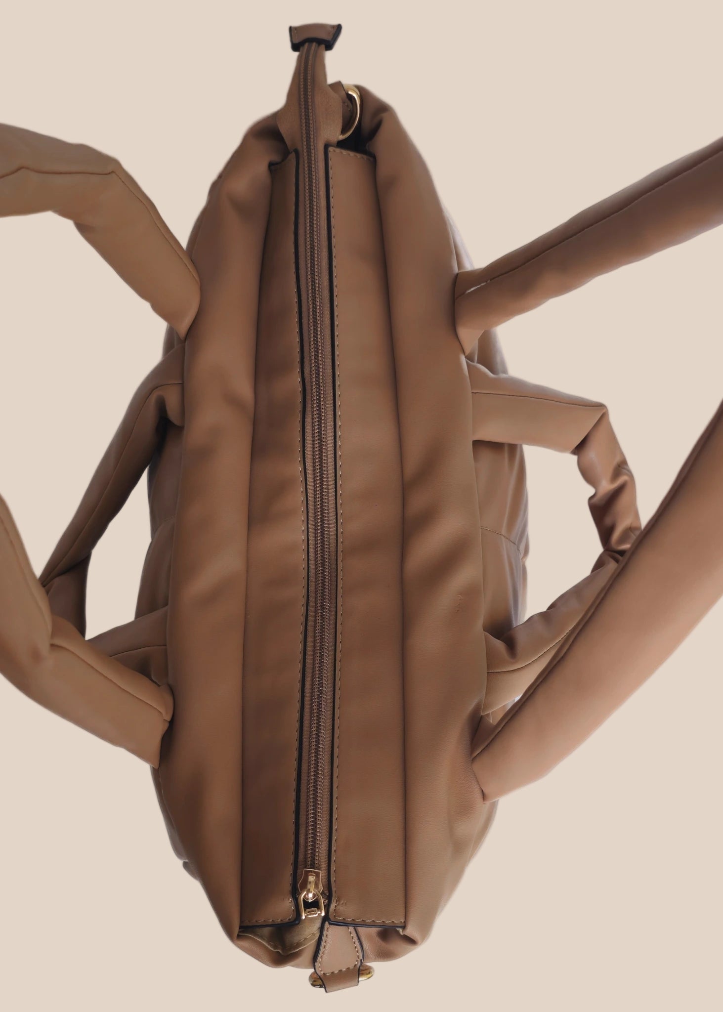 Brown smooth form handbag with a strap and handles top view