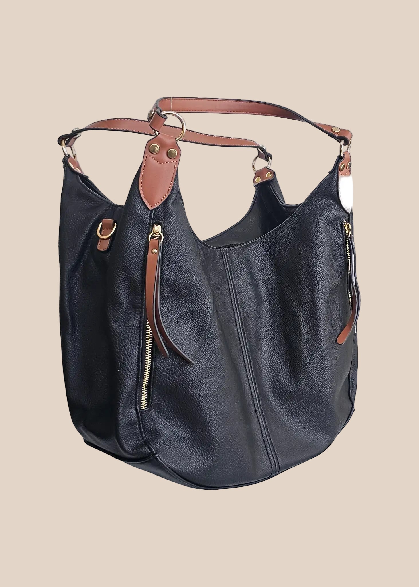 Black leather handbag with brown accents on a beige background side view