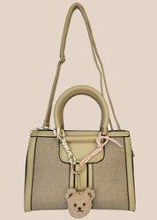 Handbag with a teddy bear charm on a beige background