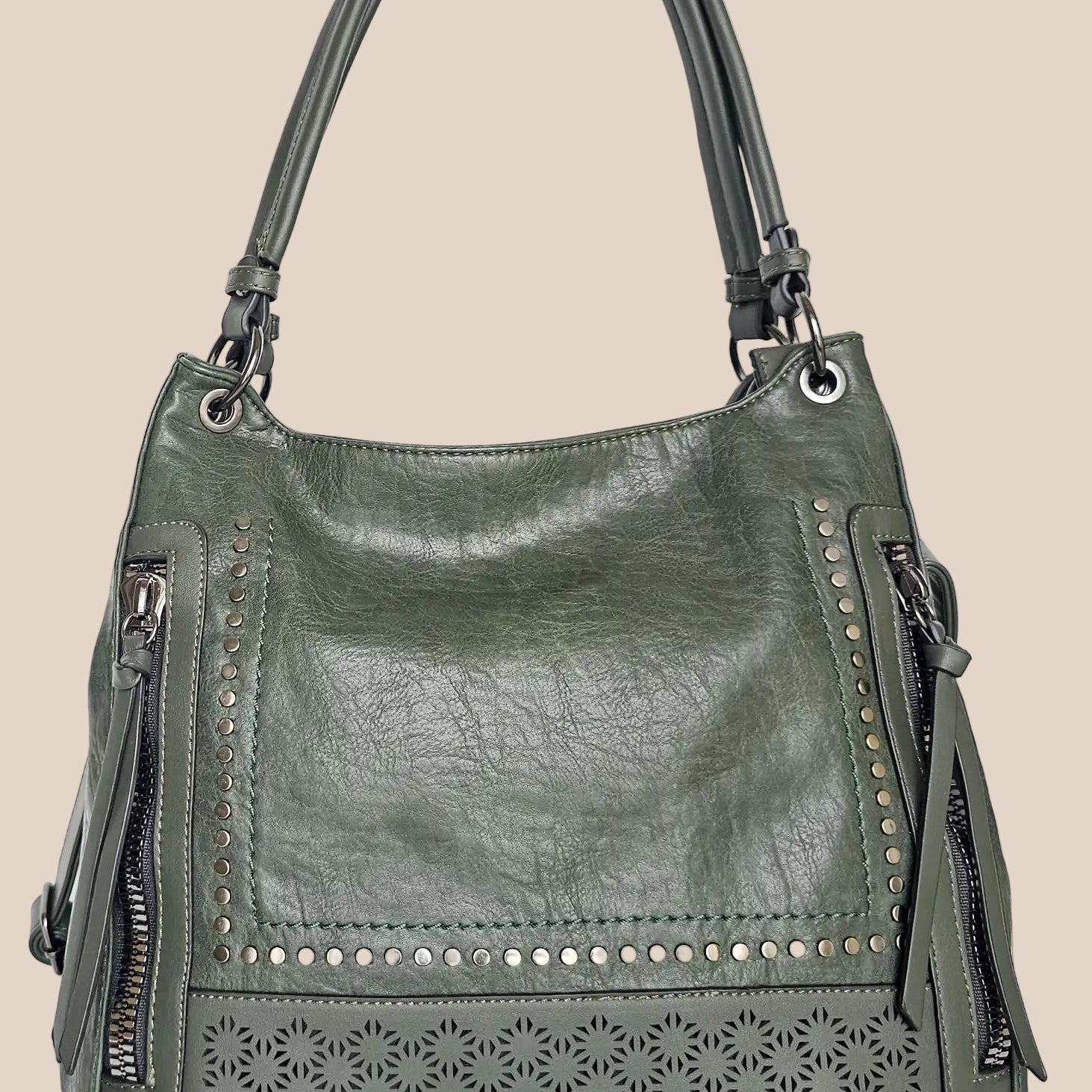Green handbag with decorative studs and cut-out patterns front view