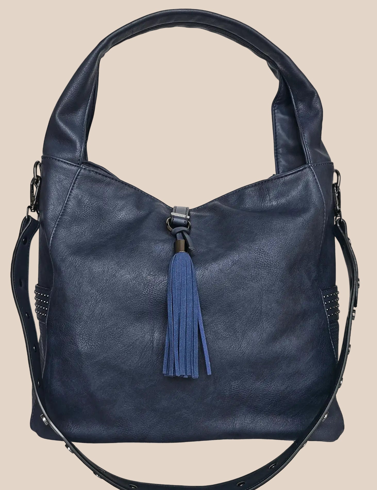 Blue handbag with a tassel on a beige background front view