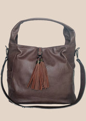 Brown leather handbag with a tassel on a beige background front view