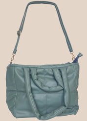 Teal quilted form handbag with a strap and handles