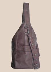 Brown leather handbag with a tassel on a beige background side view