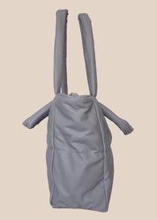 Gray smooth form handbag with a strap and handles side view