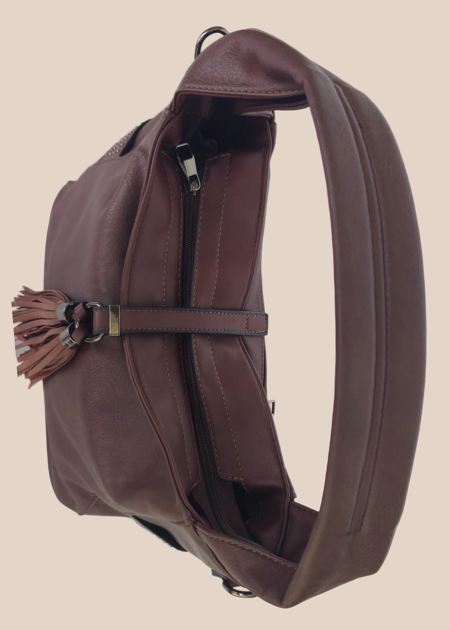 Brown leather handbag with a tassel on a beige background top view