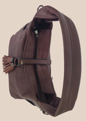 Brown leather handbag with a tassel on a beige background top view